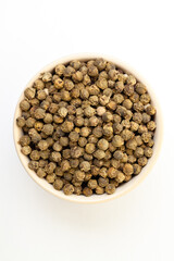 Dry green pepper spice in bowl on a white background.