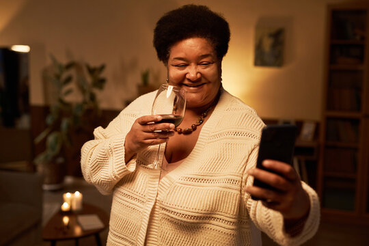 Waist Up Portrait Of Smiling Black Woman Taking Selfie Photo At Home With Glass Of Wine, Copy Space