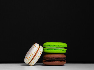 bright macaroon cookies on a black background