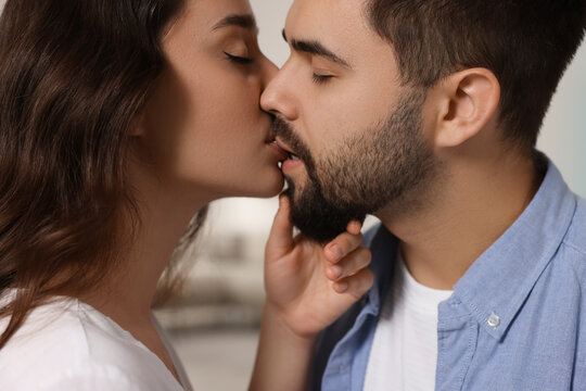 Love relationship. Passionate young couple kissing indoors, closeup