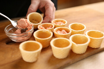 Waffle baskets are filled with fish paste. Preparation of canaps