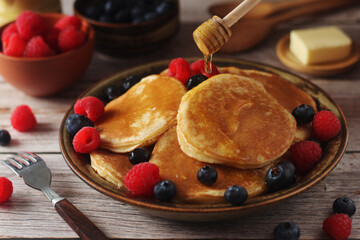 Pancakes with berries in rustic style