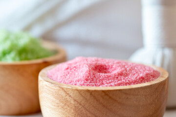 Multicolor Aromatherapy Salt in Wooden Bowl with Herbal Compress close up;Serene Spa Setting