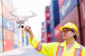 Container yard staff prepares a drone or UAV flying to survey - inspect around the container site.