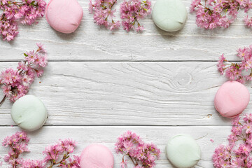 Flower composition. Frame made of spring pink blossoming flowers and marshmallows on white wooden...