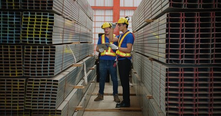 Workers partners in uniform safety and hardhat holding tablet Talking on a Meeting in Metal Construction Manufacture industry factory, Engineers man industrial discussing project work. Team work