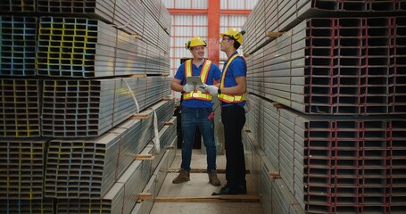 Workers partners in uniform safety and hardhat holding tablet Talking on a Meeting in Metal Construction Manufacture industry factory, Engineers man industrial discussing project work. Team work