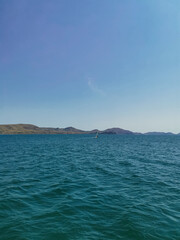 Fototapeta premium Sunny Summer Landscape of Sea, Mountains, and Sky with No People