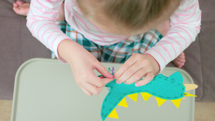 A girl is sewing a toy. Classes with children. Children's hobbies.