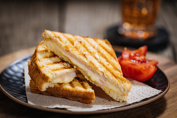 Toast sandwich with gouda cheese and turkey ham on a wooden background with ingredients in blurry...