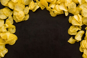 Snack background with crispy potato chips, top view