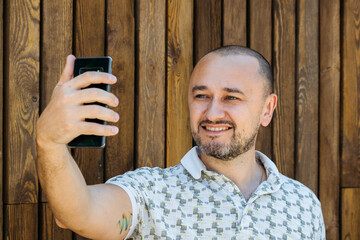 Man Taking Selfie Against Wooden Wall