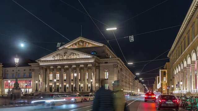 Munich National Theatre or Nationaltheater on the Max Joseph square night timelapse. Traffic on the street with trams and taxi parking. Historic opera house, home of the Bavarian State Opera. Germany