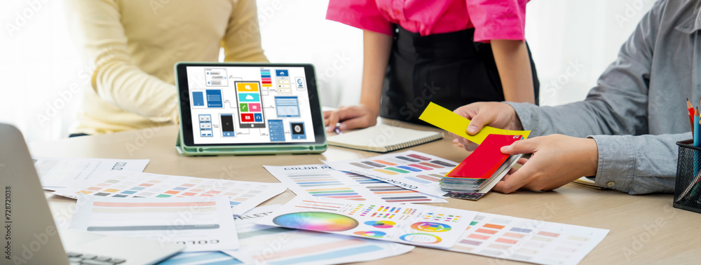 Poster cropped image of interior designer team chooses color from color swatches while tablet displayed ui 