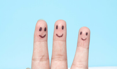 Three fingers with happy faces drawn like family or friends, fingers with smiling emojis, fingers...