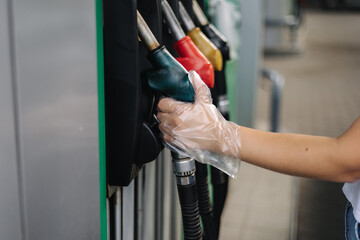 Close-up of a women's hand using a fuel nozzle at a gas station. Petrol station concept. Filling...