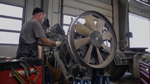 Mechanics maintain a huge truck engine