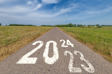 inscription 2023, 2024 and start on asphalt road highway with sunrise or sunset sky background.  concept of future, freedom, work start, run, planning, challenge, target, new year