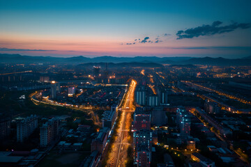 Obraz premium Aerial view of a bustling commercial district at twilight, city lights