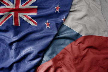 big waving national colorful flag of czech republic and national flag of new zealand .