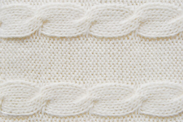 Soft ivory woolen sweater surface with cable ornament texture as background