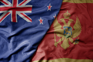 big waving national colorful flag of montenegro and national flag of new zealand .