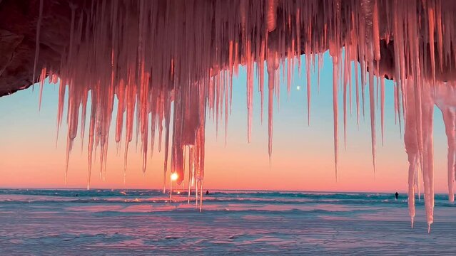 Frozen winter lake Baikal, Siberia, Russia. Ice icicles and blocks in the rocks, grottoes and caves at dawn. Natural background of cold ice. Winter abstract background. High quality 4k footage