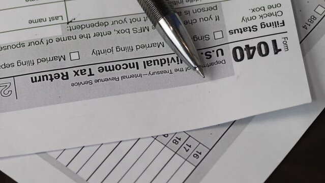 1040 tax return and pen. close-up of a rotating sheet of a tax form. paying taxes. tax laws