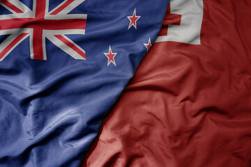 big waving national colorful flag of Tonga and national flag of new zealand .