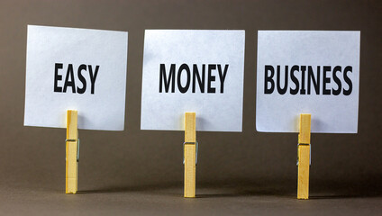 Easy money business symbol. Concept words Easy money business on beautiful white paper on clothespin. Beautiful grey table grey background. Easy money business concept. Copy space.