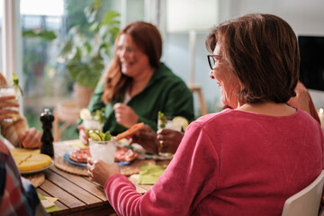Group of friends gathered eating to celebrate together. Concept: friendship, bond, fun