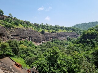 Fototapeta na wymiar Panoramic view of the Ajanta Caves surrounded by trees 