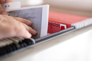 female hands through folders In Document Storage close-up, Home Archive, Record Keeping,...