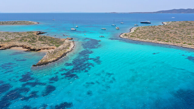 Aerial drone photo of azure paradise blue lagoon of Panteronisi a small islet complex between Paros and Antiparos islands visited by yachts and sail boats, Cyclades, Greece
