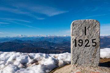 View of Dufourspitze mountain from Mount Generoso with a boarder milestone close-up