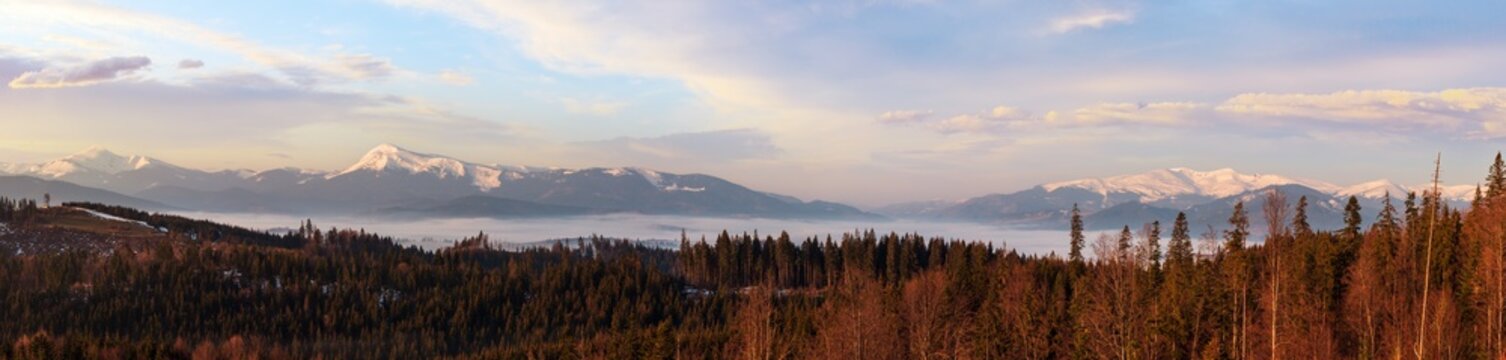 Spring dusk Carpathian mountains landscape with snow-covered ridges in far, Ukraine. From left to right - Hoverla, Petros, Blyznycja tops.