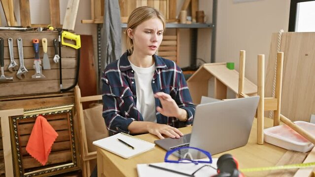 A stressed woman in a workshop with a laptop, plaid shirt, and measuring tape contemplates her project.