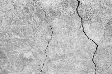 The wall of an old building with winding, deep cracks. Copy space. Black and white photo. Selective focus.