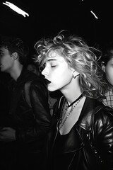 Black and white portrait of beautiful young woman with blond curly hair in leather jacket. Celebrity woman caught in a controversial moment, captured with the urgency of paparazzi photography.