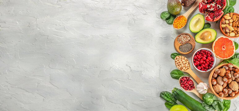 Healthy vegan food with fruits, vegetables, seeds, superfood, cereals. Foods high in vitamins, minerals and antioxidants. Long banner format. top view