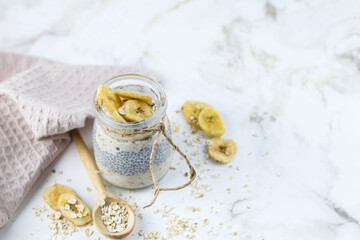 Oatmeal in a jar (lazy oatmeal) with bananas and chia seeds. Healthy breakfast concept.