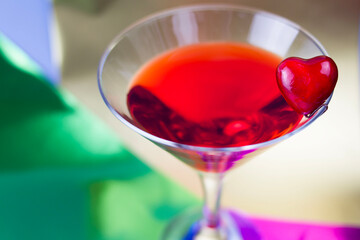 red cocktail in a martini glass on a colored background