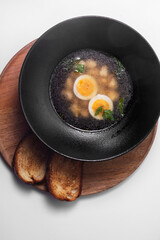 Delicious soup with eggs and fried bread isolated on white background