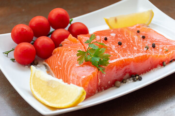 Juicy salmon fillet with tomatoes, lemon and herbs