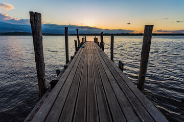 Obraz premium Path over the wooden pier, with a beautiful view of Vitória Bay and the Espírito Santo mountains during a peaceful late afternoon
