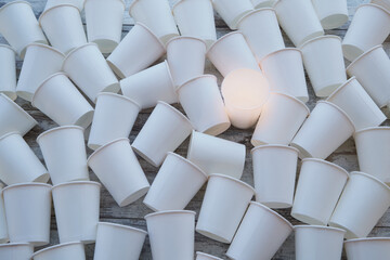 White paper cups scattered on the table and one is glowing with warm light. The right solution from...