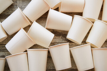 White paper cups scattered on the floor in warm sunlight close-up