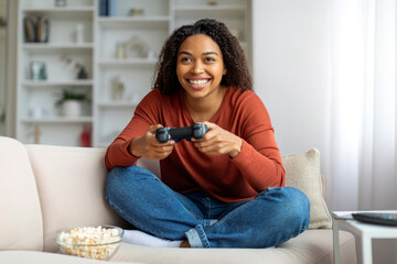 Domestic Fun. Cheerful Young Black Woman Playing Video Games At Home