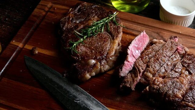 sliced ribeye steak on wooden board