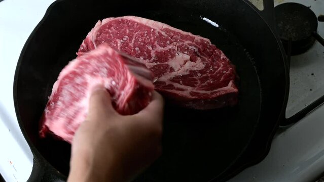 cooking ribeye steak on iron cast skillet pan
